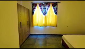a room with yellow walls and a door and a window at Gibbi's on the Beach in Elephant Island