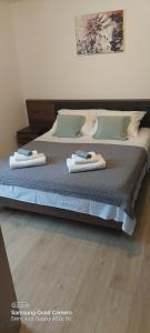 a large bed with two towels on top of it at Room Depikolo 2 in Krk