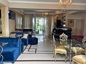 ein Wohnzimmer mit einem blauen Sofa und Stühlen in der Unterkunft Diamond Hotel in Chişinău