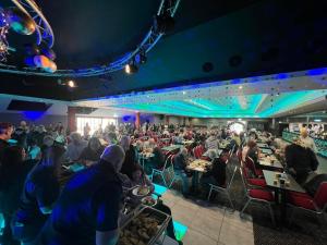 a crowd of people sitting at tables in a room at Lyon's Robin Hood Rhyl 8 Berth Caravan in Rhyl +20 photos