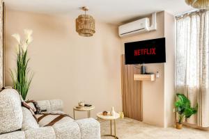 a living room with a couch and a tv at La Sensuelle Suite with spa in Vendres