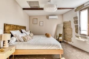 a bedroom with a large white bed and a window at La Sensuelle Suite with spa in Vendres