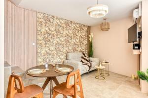 a living room with a table and a couch at La Sensuelle Suite with spa in Vendres +22 photos