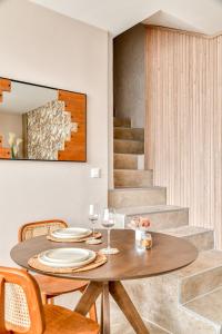 a dining room with a table and chairs and stairs at La Sensuelle Suite with spa in Vendres