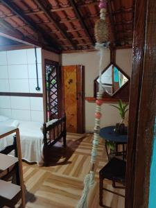 a room with a bed and a table with a rope at Pousada Oliveira Ramos in Lumiar
