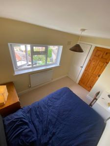a bedroom with a blue bed and a window at Peaceful Fields in Lancaster