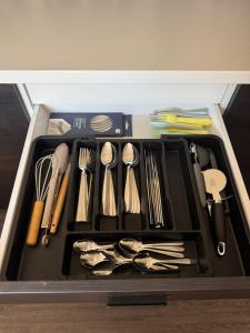 a drawer filled with utensils in a container at Spacious 3BR Flat near Newcastle Centre in Saint Peters