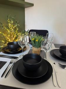 a table with black plates and wine glasses on it at Spacious 3BR Flat near Newcastle Centre in Saint Peters