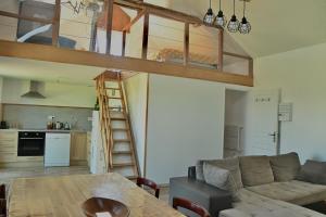 a living room with a loft bed and a table at La Giraudière avec climatiseur 2 à 4 personnes in Soulgé-sur-ouette