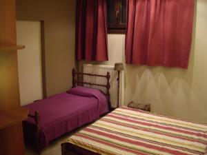 two beds in a room with red curtains at Evelin Apartment in Portaria +6 photos