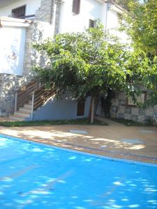 a blue swimming pool in front of a building at Evelin Apartment in Portaria