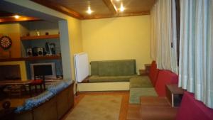 a living room with a couch and a tv at Evelin Apartment in Portaria