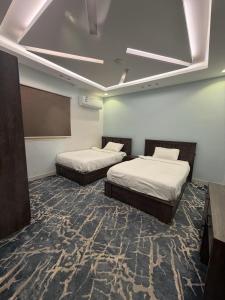 a room with two beds and a chalkboard at Dar Al-Areed in Medina
