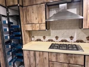 a kitchen with wooden cabinets and a stove top oven at Dar Al-Areed in Medina