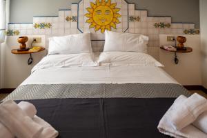 a bedroom with a large bed with a sun on the wall at B&B Tirreno- Finestra sul Mare in Contrada Mastrissa