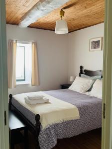 a bedroom with a bed and a wooden ceiling at Casa da Lurdinhas in Tabuaço +32 photos