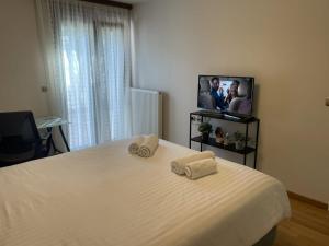 a bedroom with a white bed with two towels on it at The Ioannina Lodge in Ioannina