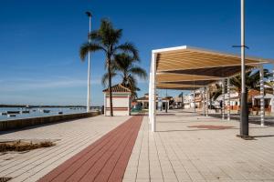 a pavilion on a boardwalk next to the water at Cornise in El Rompido