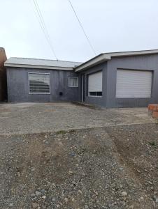 an empty parking lot in front of a garage at Casa Ruta 3 Río Gallegos in Río Gallegos