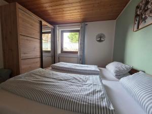 two twin beds in a room with a window at Kleines Glück am Bärenstein in Gößweinstein