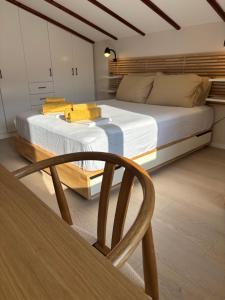 a bedroom with a large bed and a chair at Centraal Blue in Iraklitsa