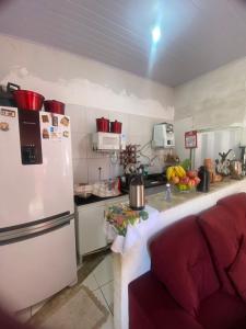 a kitchen with a white refrigerator and a red couch at Quarto para o Moto GP in Goiânia