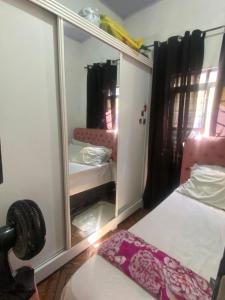 a room with a mirror and two beds in it at Quarto para o Moto GP in Goiânia