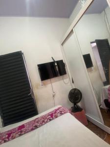 a bedroom with a mirror and a bed and a tv at Quarto para o Moto GP in Goiânia