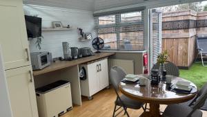 a small kitchen with a table and a table and chairs at Berrow Breeze in Burnham on Sea +17 photos