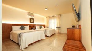 a hotel room with two beds and a flat screen tv at Hotel Marques Del Valle in Oaxaca City +36 photos