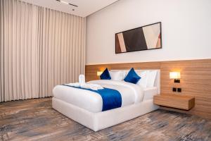 a bedroom with a large bed with a television on the wall at فندق ارجان بارك طويق 2 in Riyadh