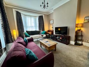 a living room with a couch and a tv at Regents Chambers in Bishop Auckland