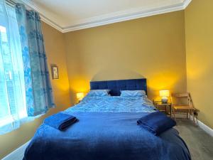 a bedroom with a large blue bed with blue sheets at Regents Chambers in Bishop Auckland