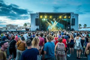 a crowd of people standing in front of a stage at meze34 in Mèze