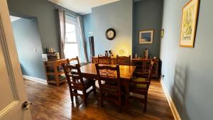 a dining room with a table and chairs and a clock at Regents Chambers in Bishop Auckland
