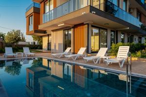 a house with a swimming pool with lounge chairs next to it at VISTA SERENA Ermenek in Altınkum
