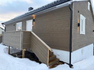 a house with a large deck in the snow at apartment With fantastic view and parking in Tromsø