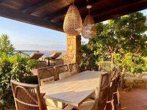 a wooden table and chairs on a patio at Li Junchi in Costa Paradiso