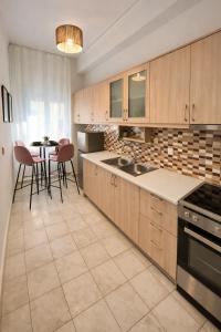 a kitchen with wooden cabinets and a table with chairs at Wake in the Lake III in Agios Nikolaos