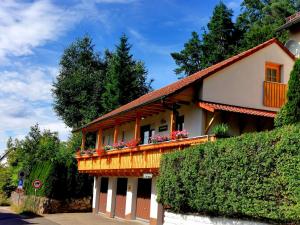 a house with a balcony with flowers on it at Kleines Glück am Bärenstein in Gößweinstein