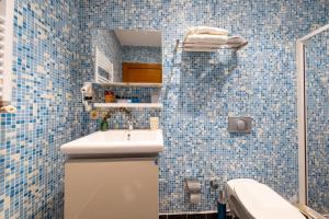 a blue tiled bathroom with a sink and a mirror at King Suite Hotel Beşiktaş in Istanbul +47 photos