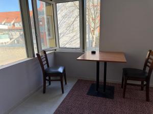 a table and two chairs in a room with windows at Pension am Schloss in Meiningen
