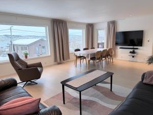 a living room with a table and chairs and a television at apartment With fantastic view and parking in Tromsø