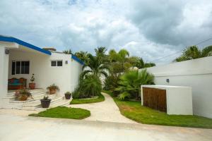 a white house with a yard with palm trees at Casa Portofino in Chuburná