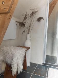 a white vase with a plant in a room at Villa Kakelbont in Leeuwarden +27 photos