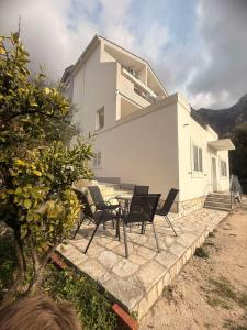 a patio with chairs and a table in front of a house at Apartman Danilo i Filip in Risan