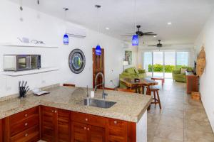 a kitchen with a sink and a living room at Casa Portofino in Chuburná