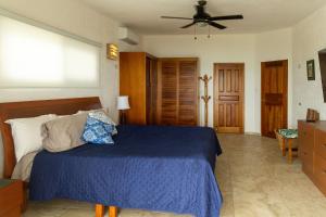 a bedroom with a bed and a ceiling fan at Casa Portofino in Chuburná +20 photos
