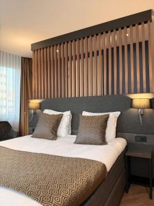 a bedroom with a large bed with two pillows at OZO Hotels Antares Amsterdam Schiphol Airport in Hoofddorp