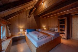 a bedroom with a bed in a wooden house at Reichart Apartment in Lochau